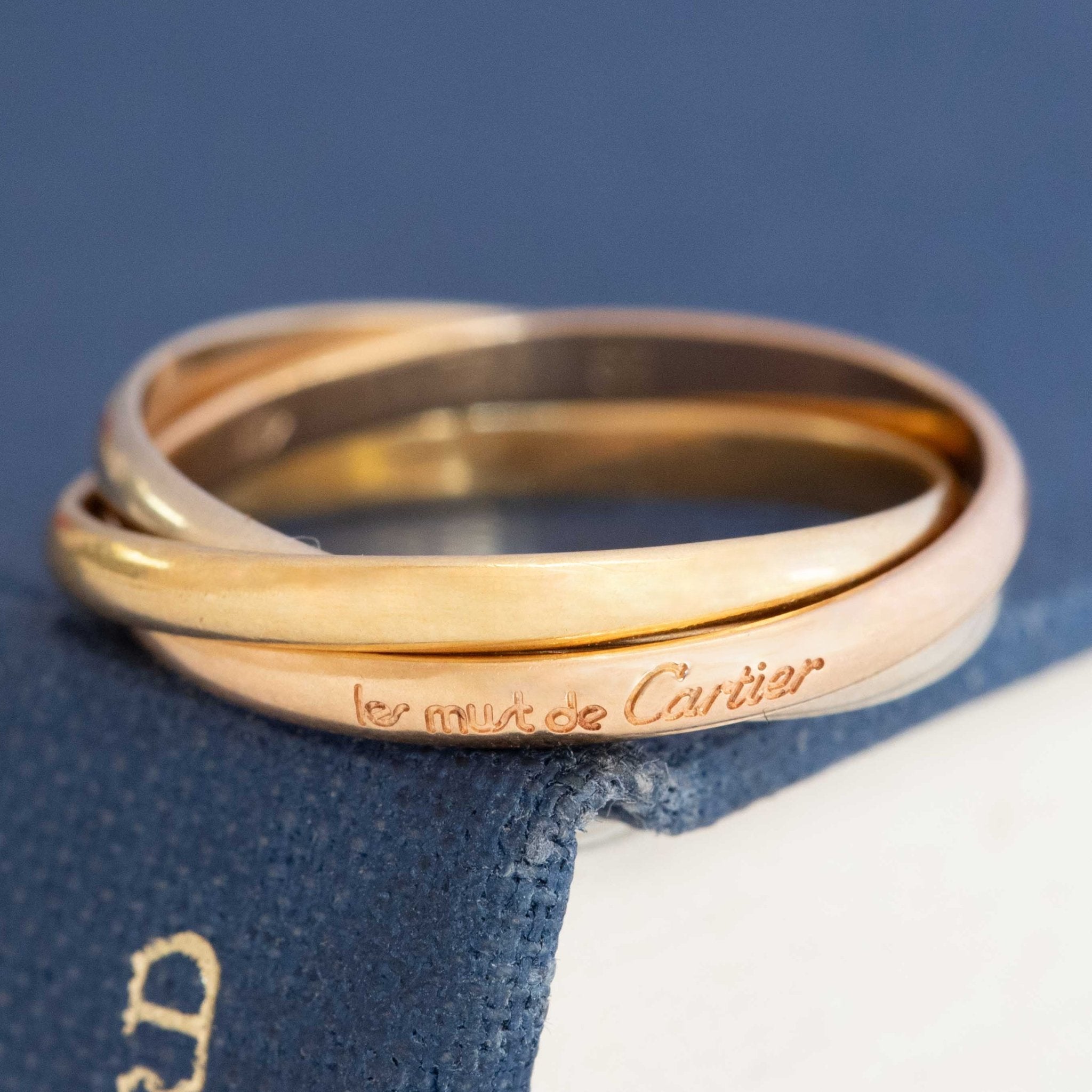 Le Must de Trinity Rolling Ring by Cartier, three gold bands interlocked