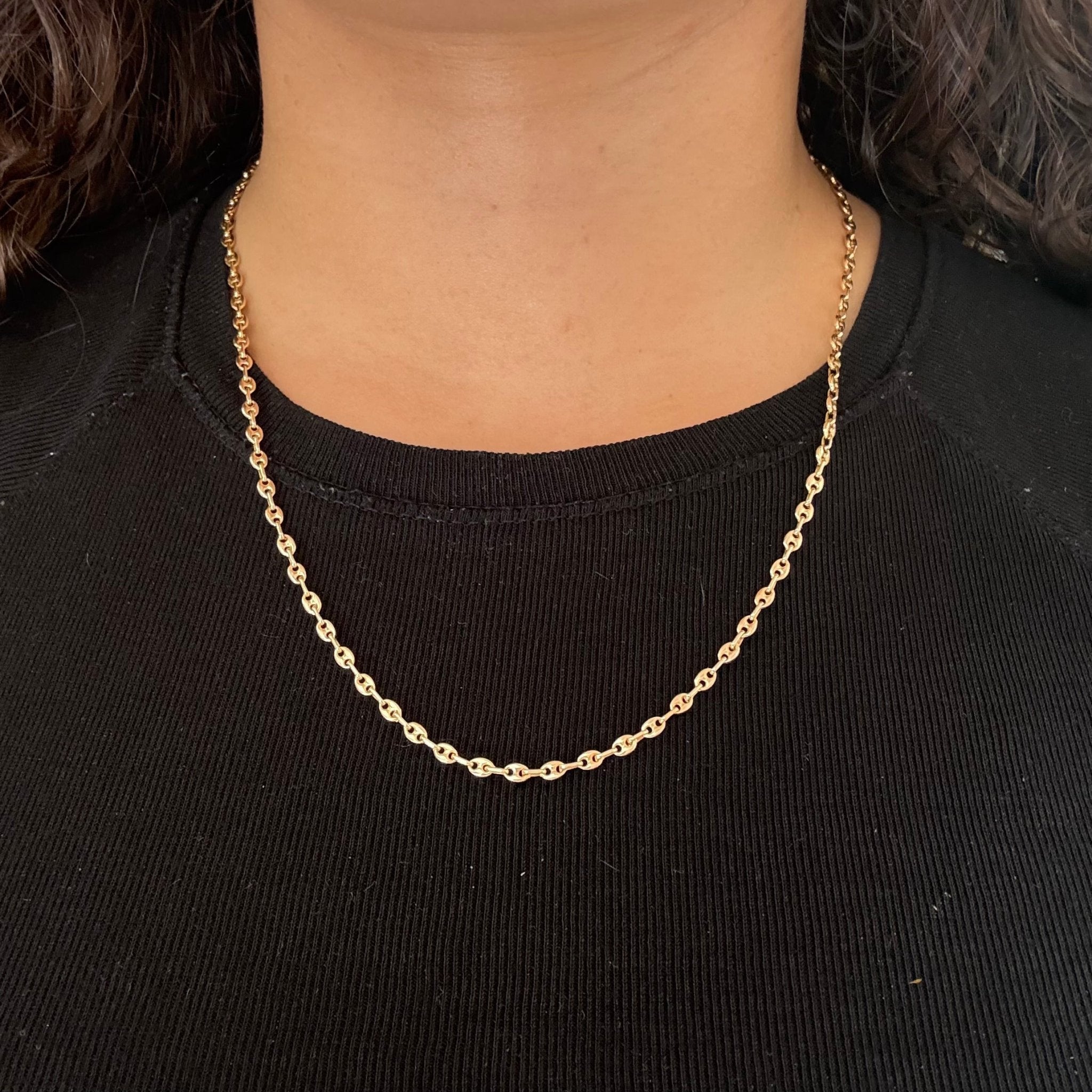 Detailed view of mid-century 14kt yellow gold anchor link chain worn on neck