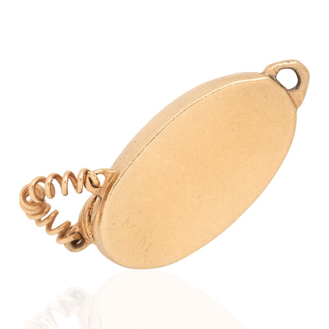 The bottom side of a vintage gold rotary phone charm