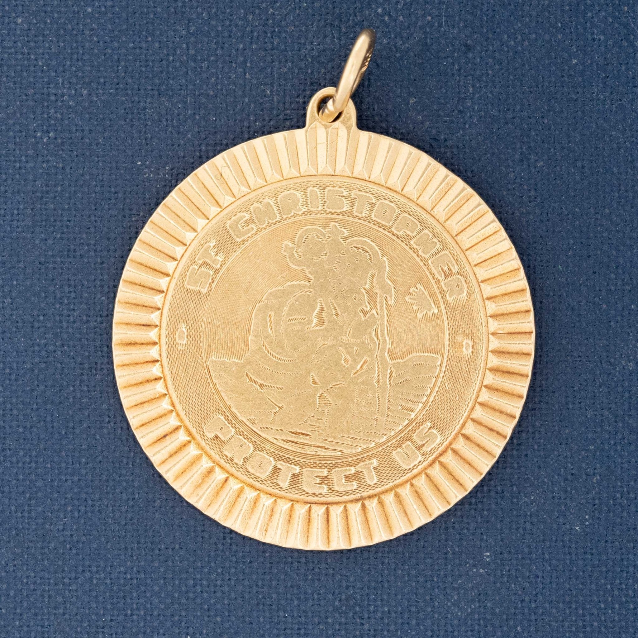 Gold pendant with a religious figure on a blue background