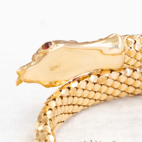 a beautiful vintage serpent themed bracelet with beautiful, realistic texture in rich yellow gold and ruby eyes.