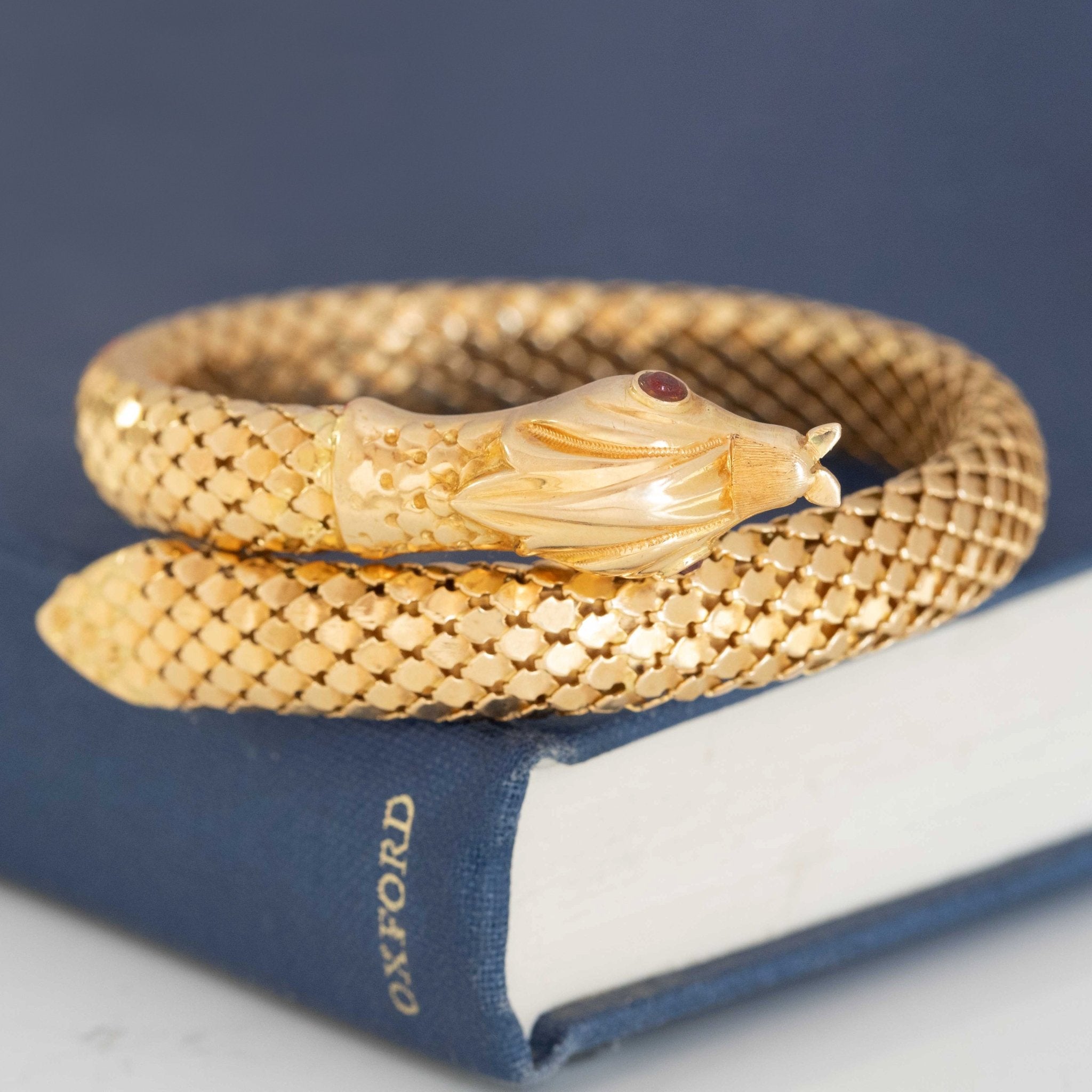 a beautiful vintage serpent themed bracelet with beautiful, realistic texture in rich yellow gold and ruby eyes.