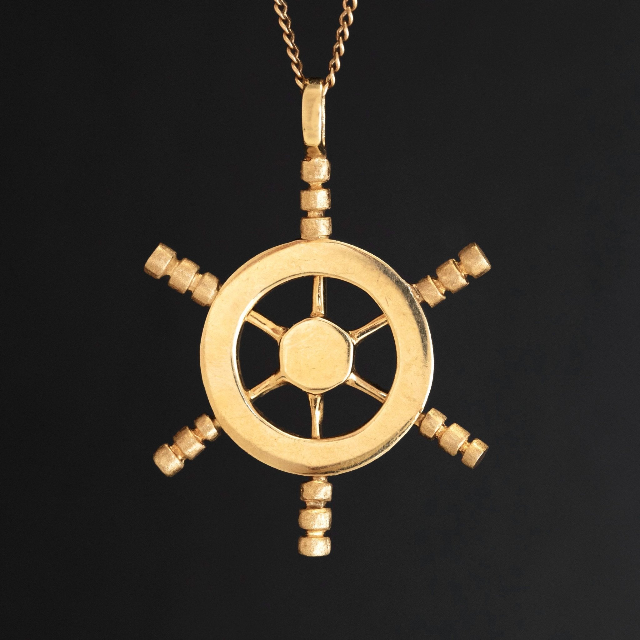 Vintage 14k yellow gold ship’s wheel pendant, nautical-inspired jewelry charm.