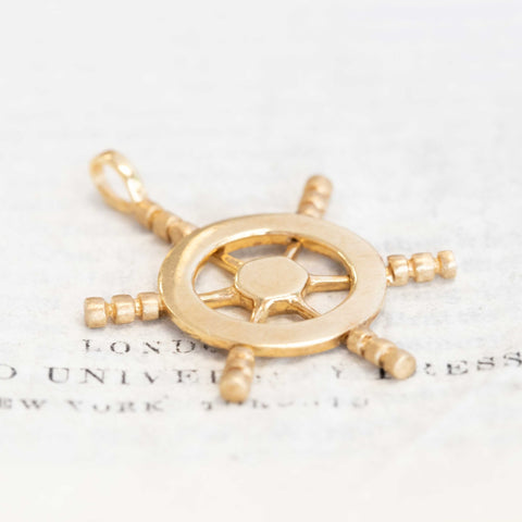 Solid 14k gold ship wheel charm pendant, maritime-inspired collectible jewelry.