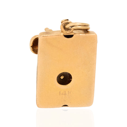 The bottom side of a Vintage Square Rotary Phone Charm stamped "14kt"