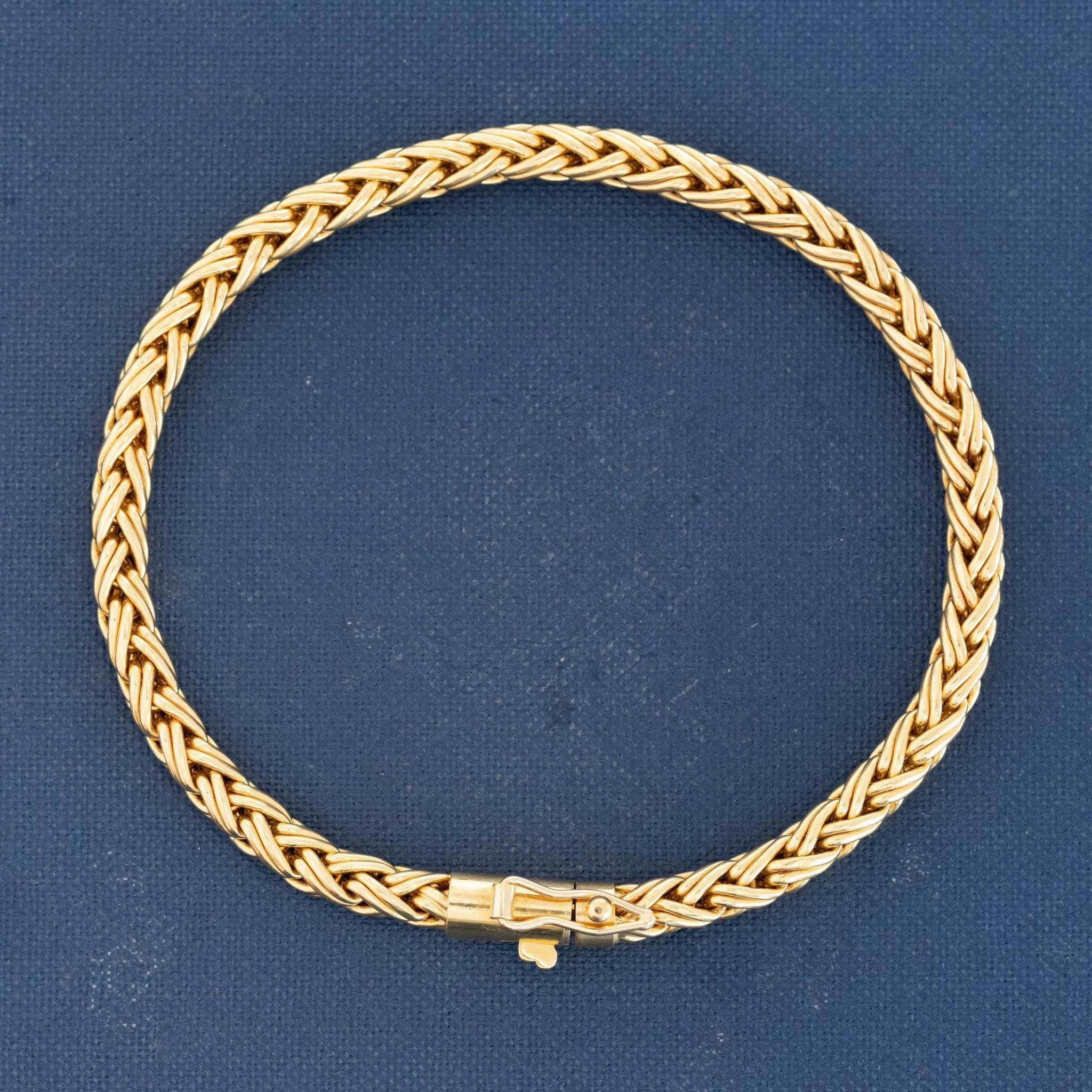Vintage Tiffany woven 18k gold bracelet on blue background